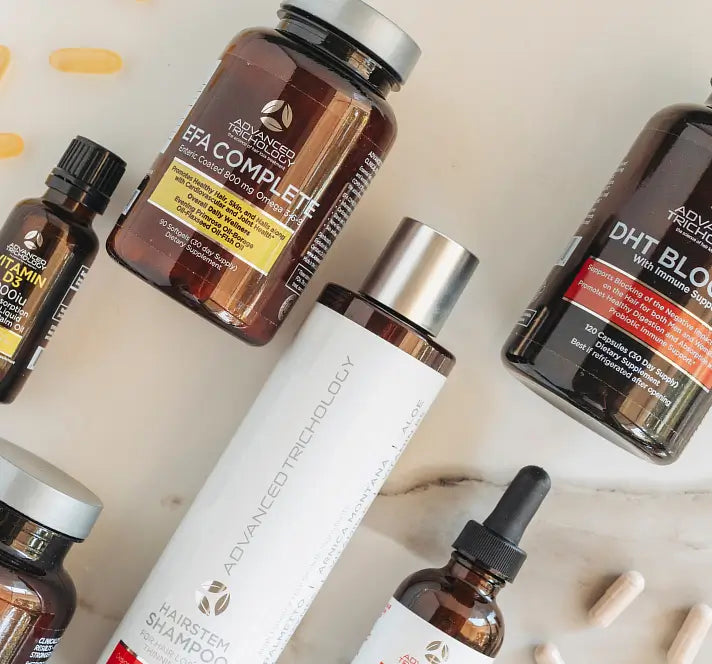 Advanced Trichology supplements and shampoo laid out on a marble surface