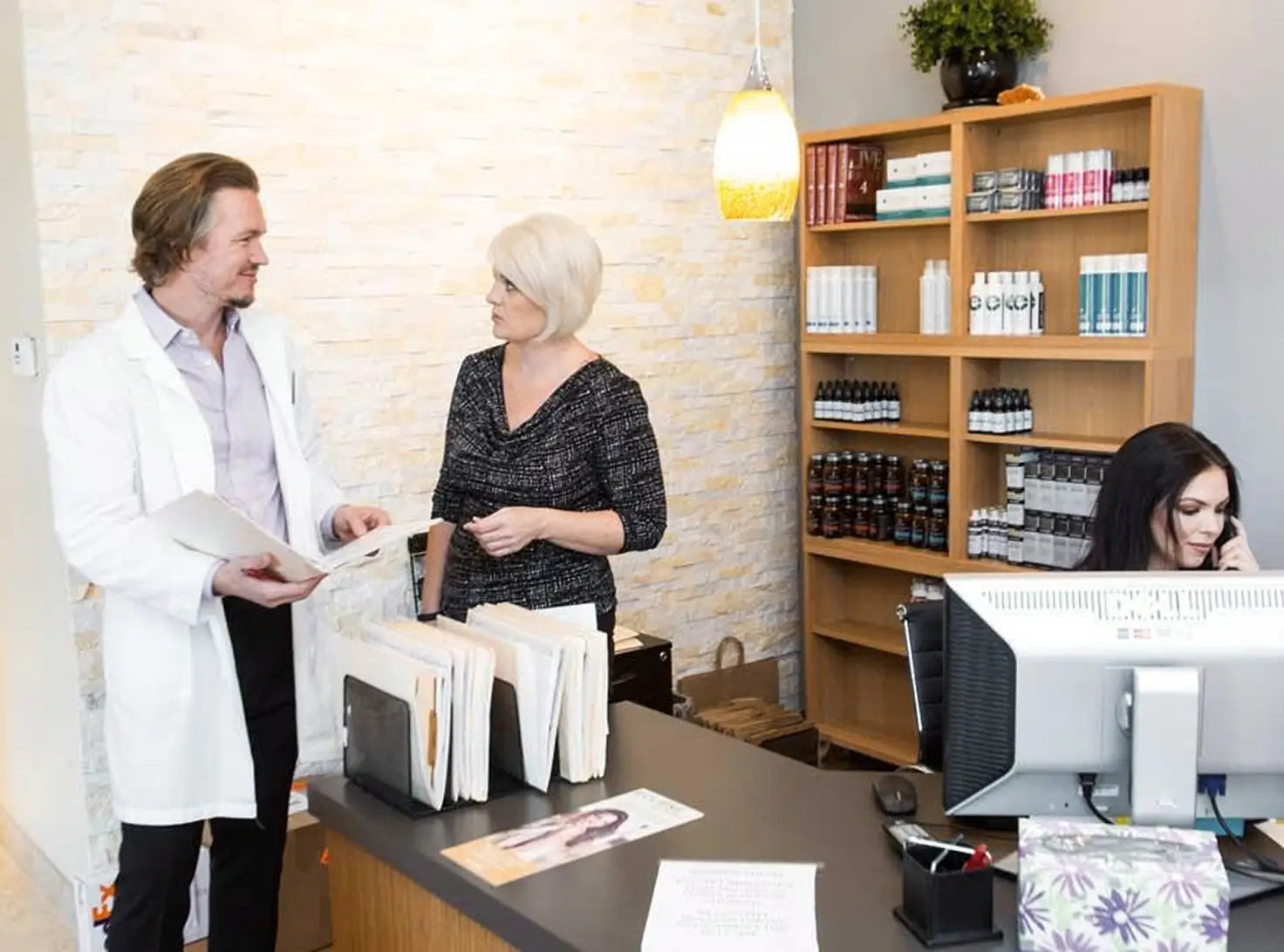 William Gaunitz talking with a client at the Advanced Trichology clinic front desk